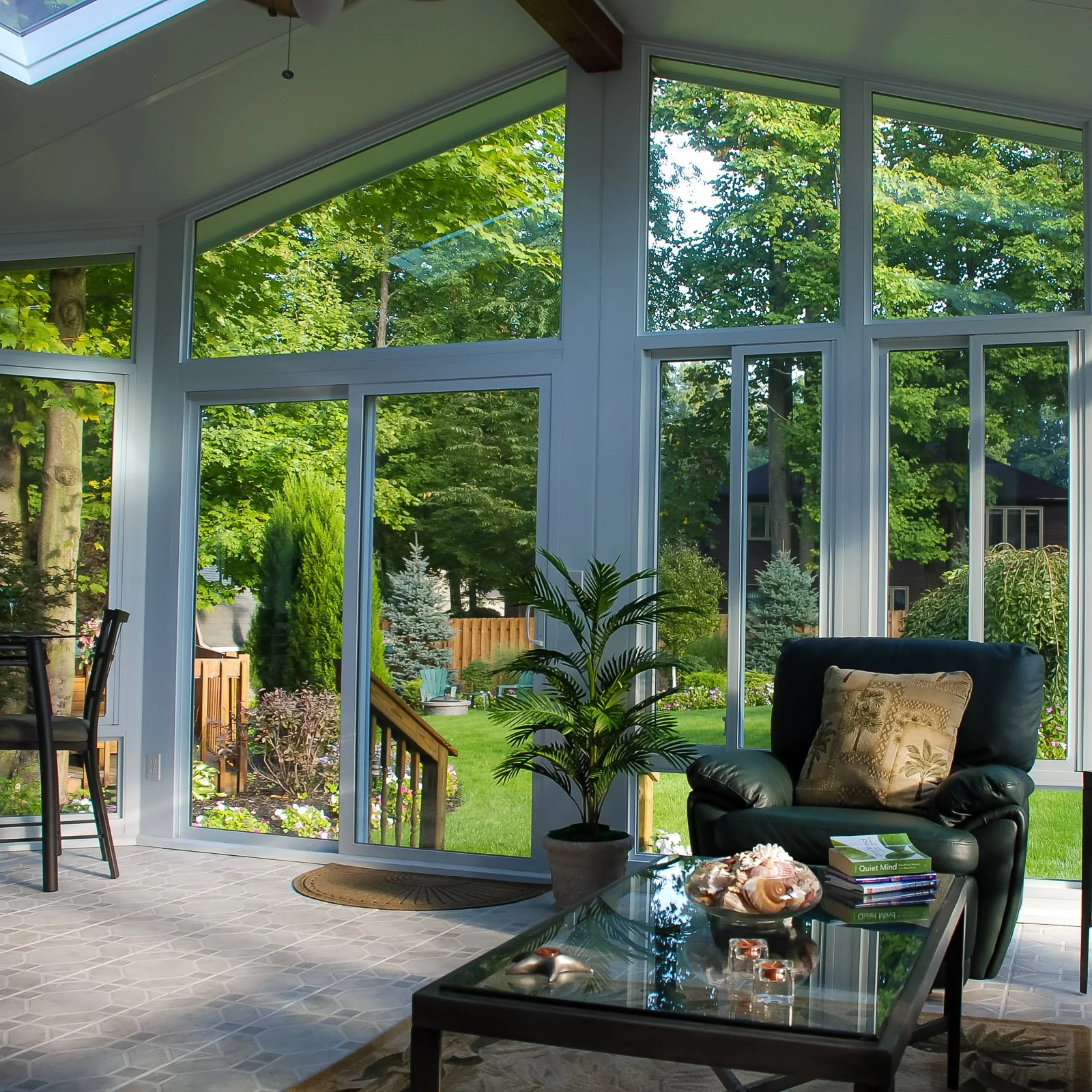 Glass sunroom opening to a wooded yard